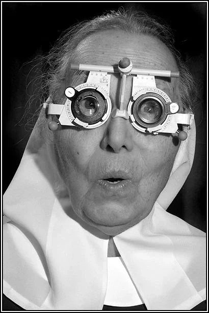 Nun having eyes tested for reading glasses