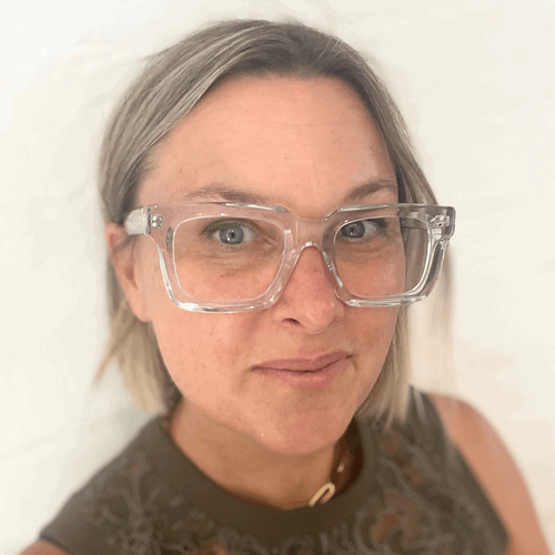 Australian woman wearing stylish clear glasses against a plain background