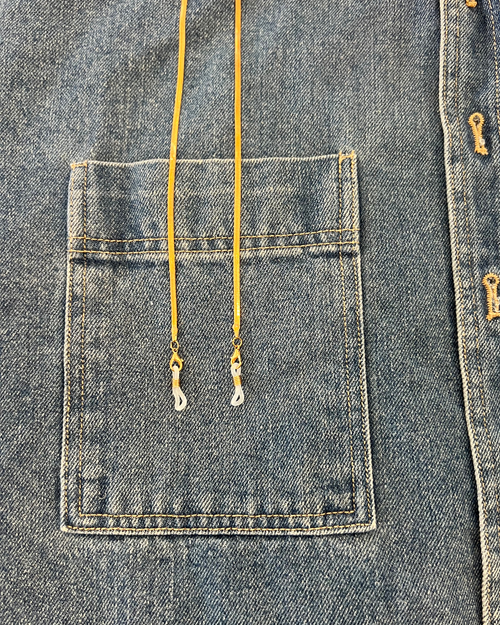 Gold flat lay snake chain glasses accessory on denim jacket