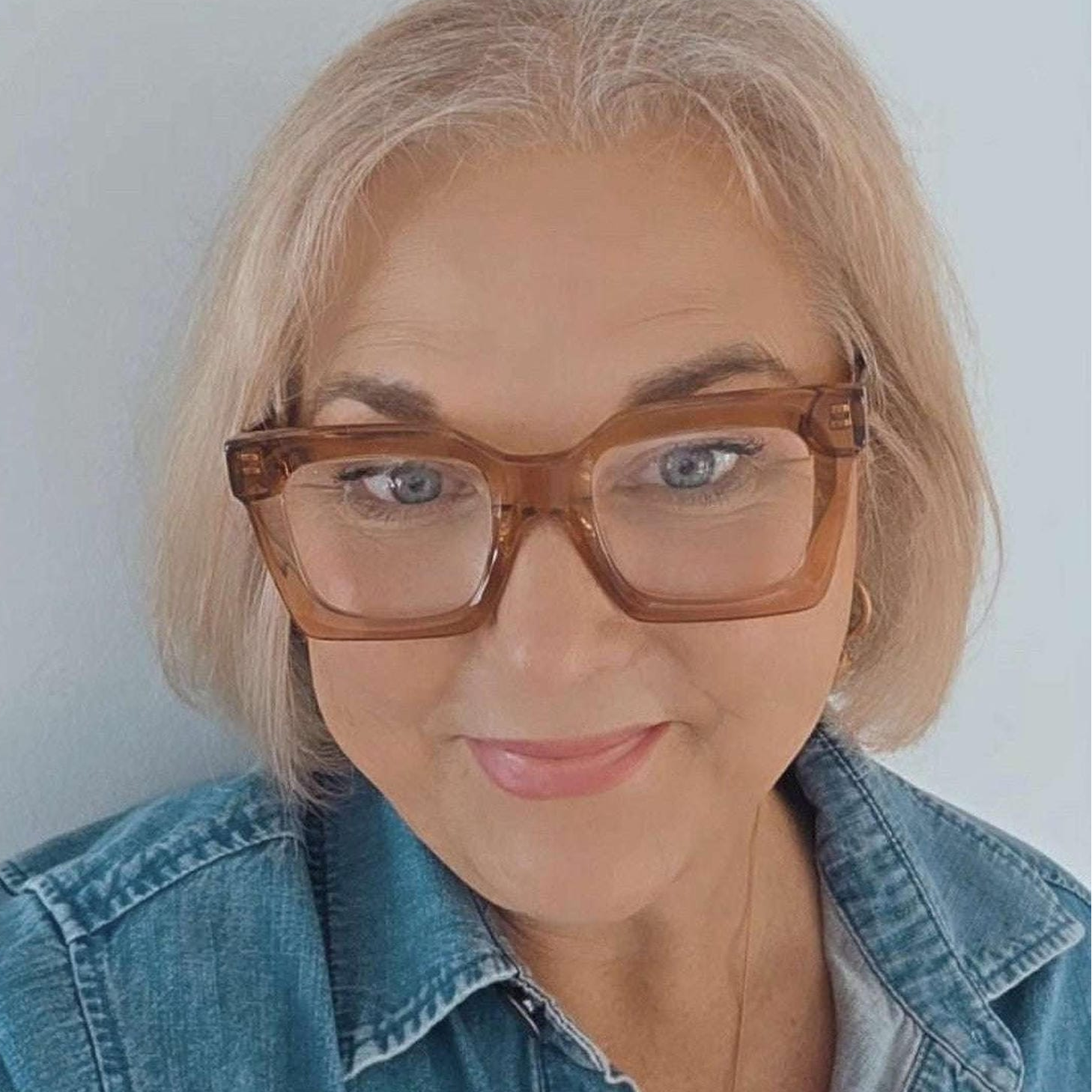 Australian stylish trendy woman wearing pink taupe reading glasses with blonde hair and denim shirt ministry of sight readers
