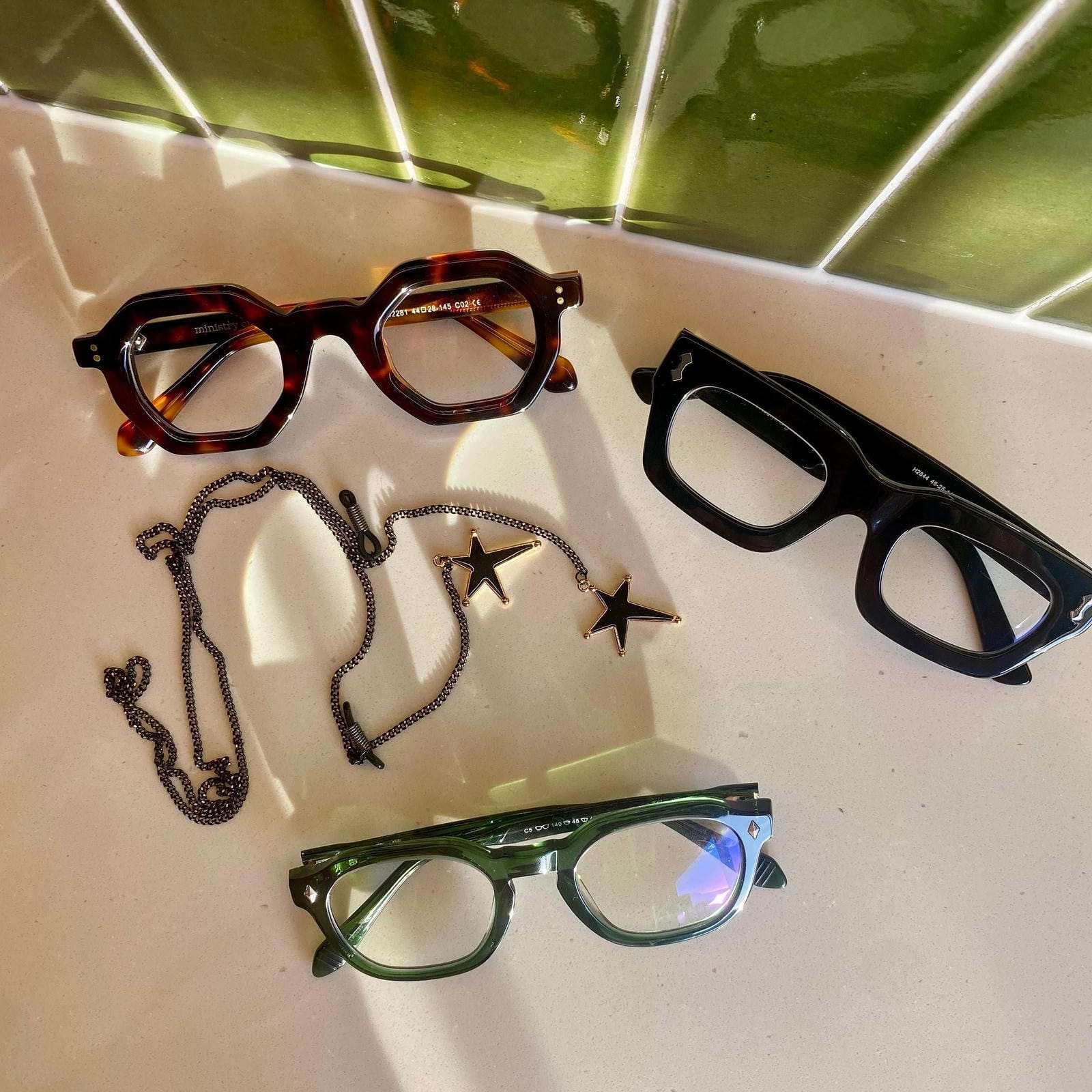 Flat Lay of four pairs of Ministry of Sight Reading Glasses and Rock Star glasses Chain