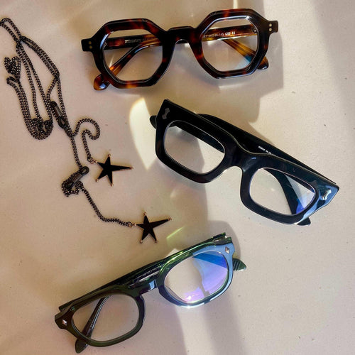 Flat Lay of three pairs of Ministry of Sight Reading Glasses and Rock Star glasses Chain