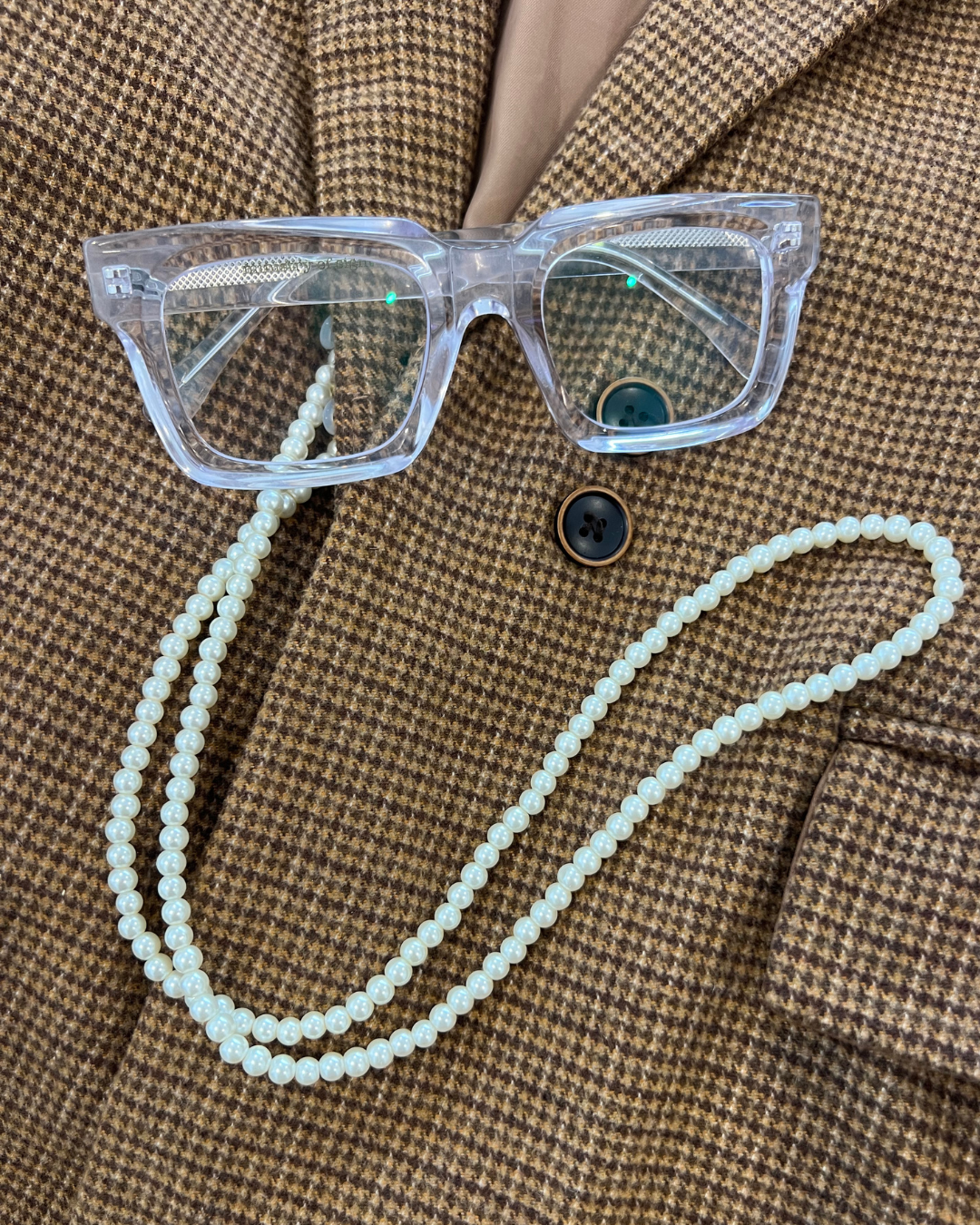 Houndstooth blazer jacket with pearl glasses and sunglasses chain accessory so you don't lose your glasses, Clear square reading glasses. Ministry of Sight.