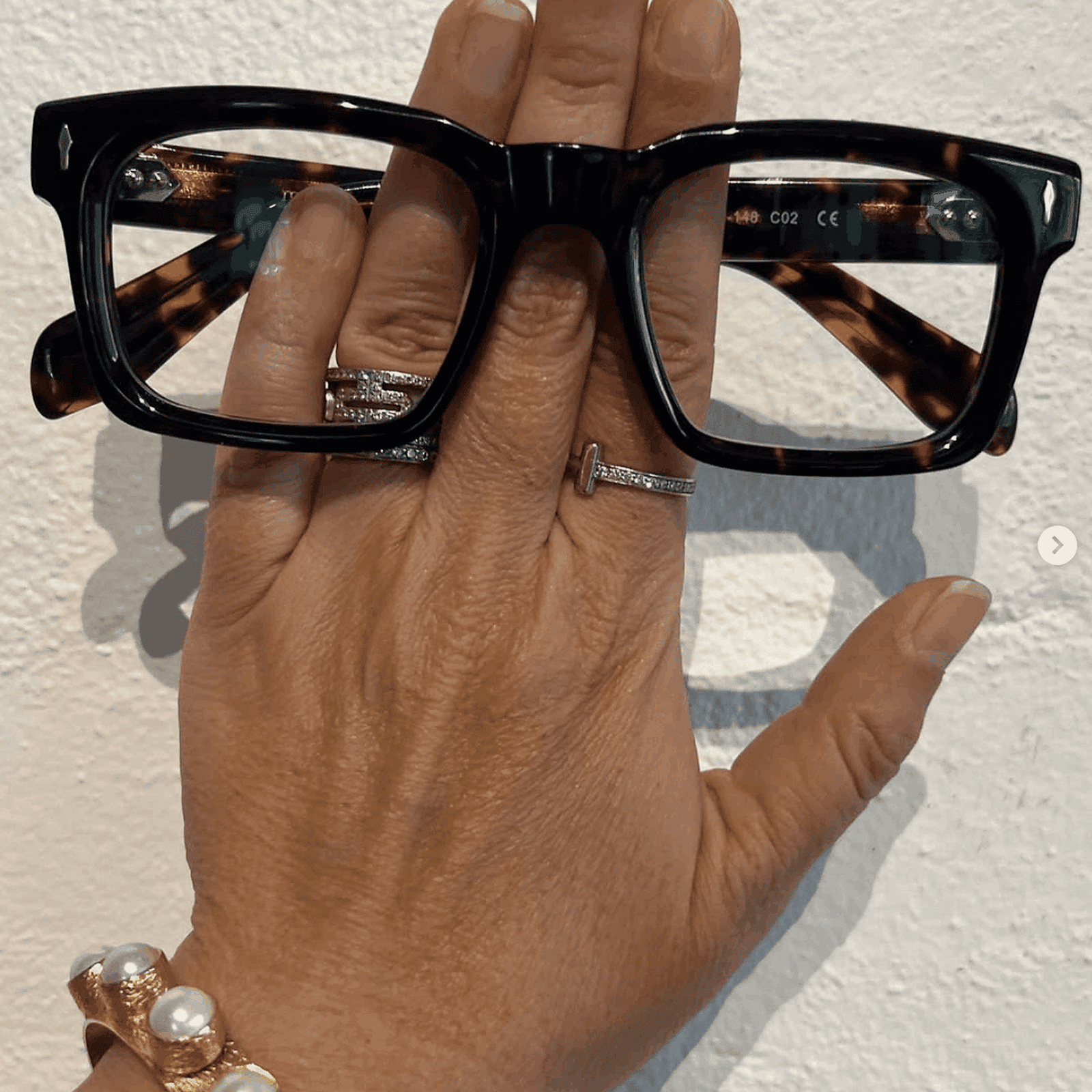 Hand holding a pair of tortoiseshell reading glasses - The Nerds - Ministry of Sight