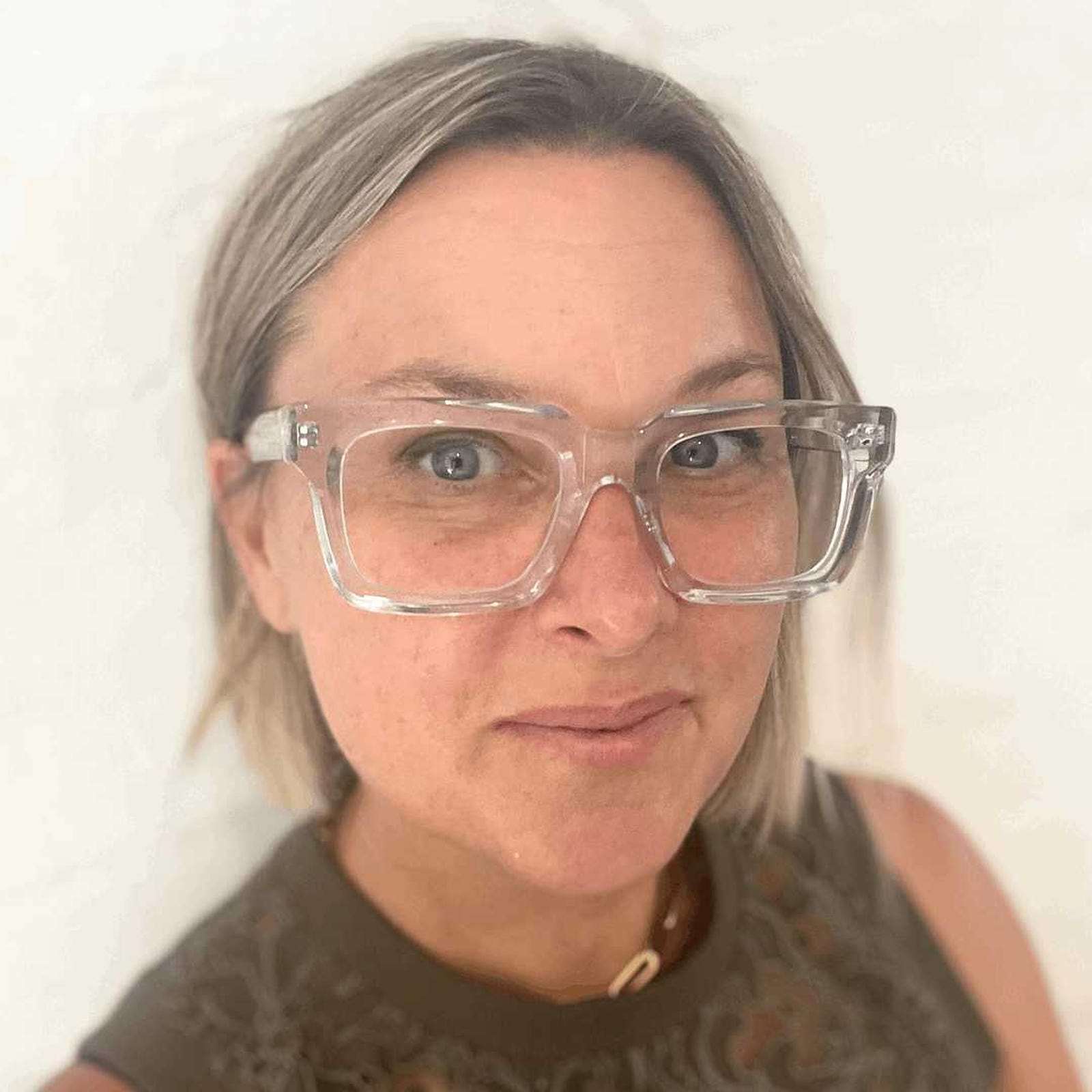 Australian woman wearing stylish clear glasses against a plain background - Ministry of Sight