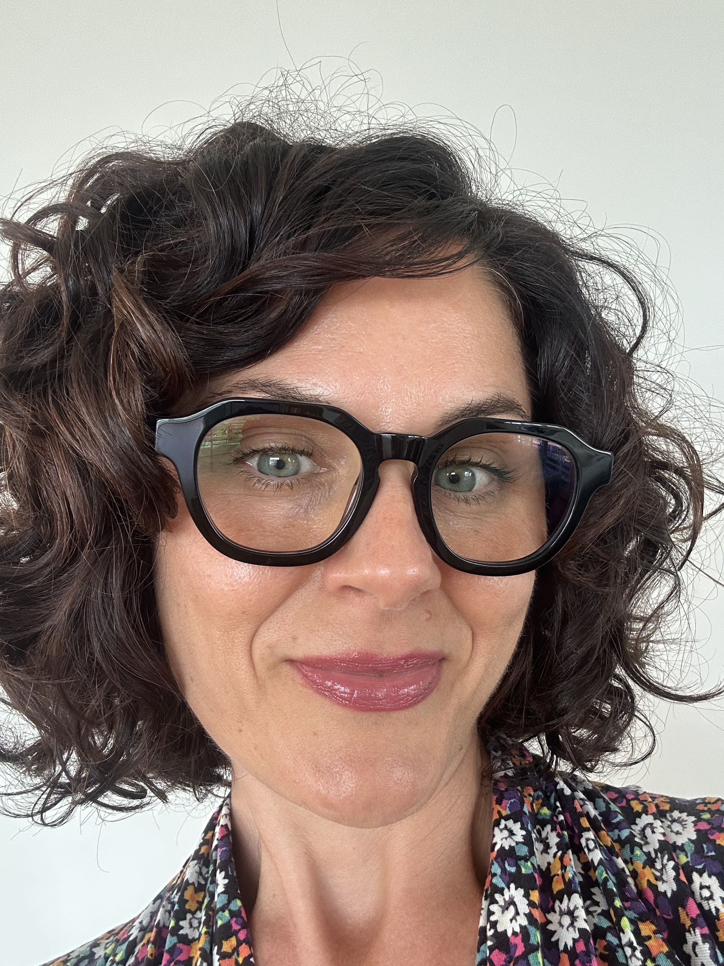 Australian woman in a floral top wearing The Flat Top black reading glasses  - ministry of sight readers
