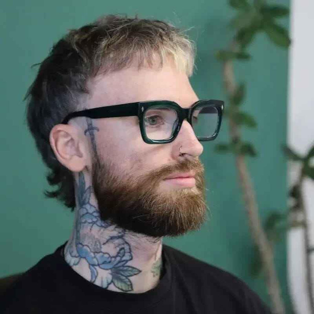 Man with tattoos wearing The Standards green cool reading glasses