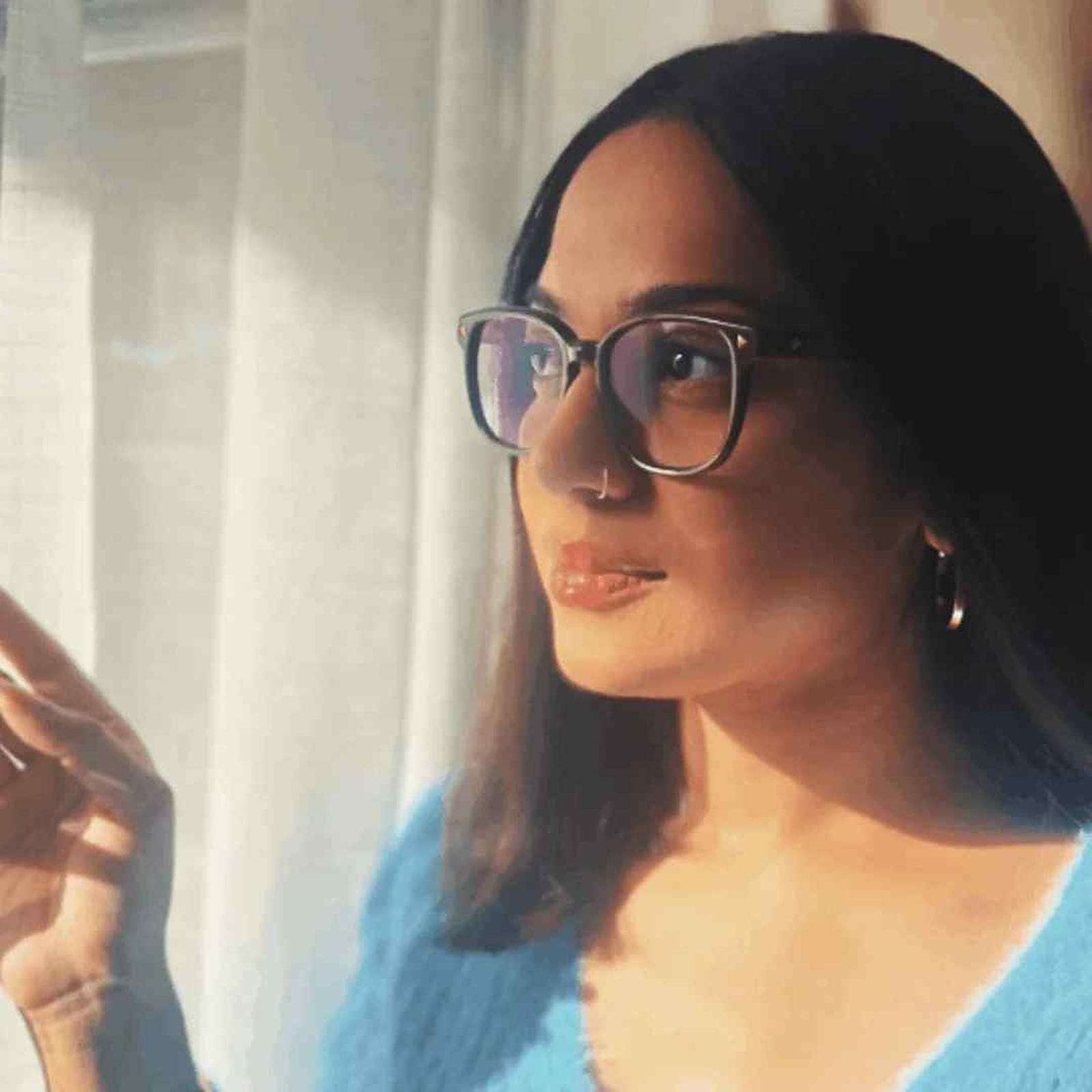 Woman wearing brown reading glasses and a blue sweater in front of a window - Ministry of Sight stylish readers - The Mod