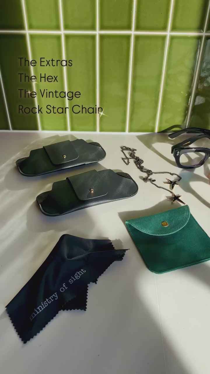 Ministry of Sight reading glasses and rock star chain flat lay in kitchen